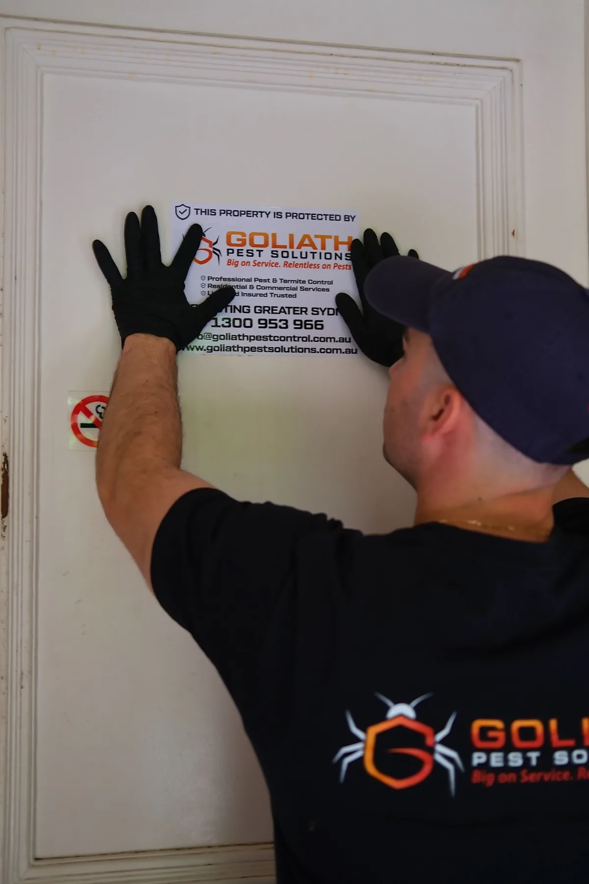 Goliath Pest Solutions technician applying a property protection sticker